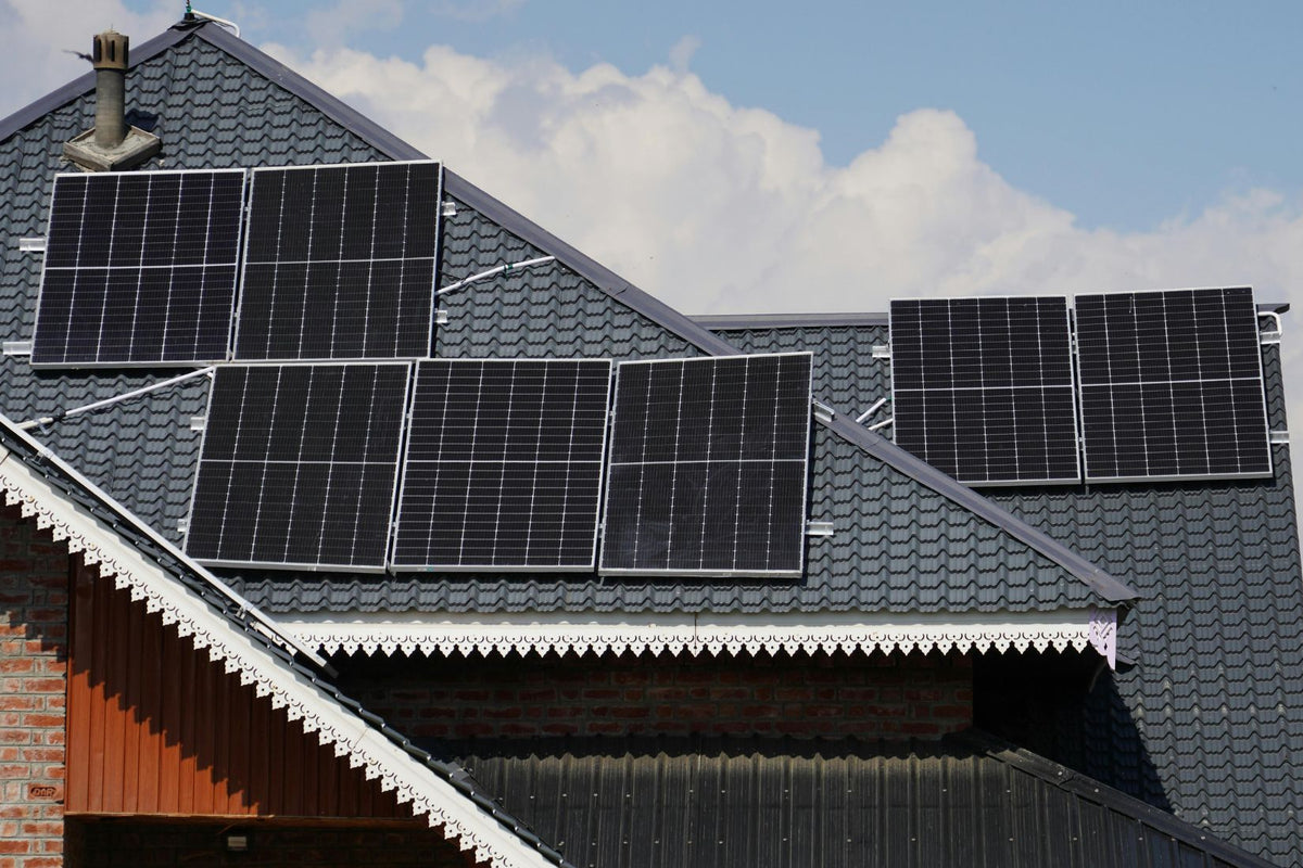 Hawke’s Bay home with solar panels on the roof and a heat pump unit outside.